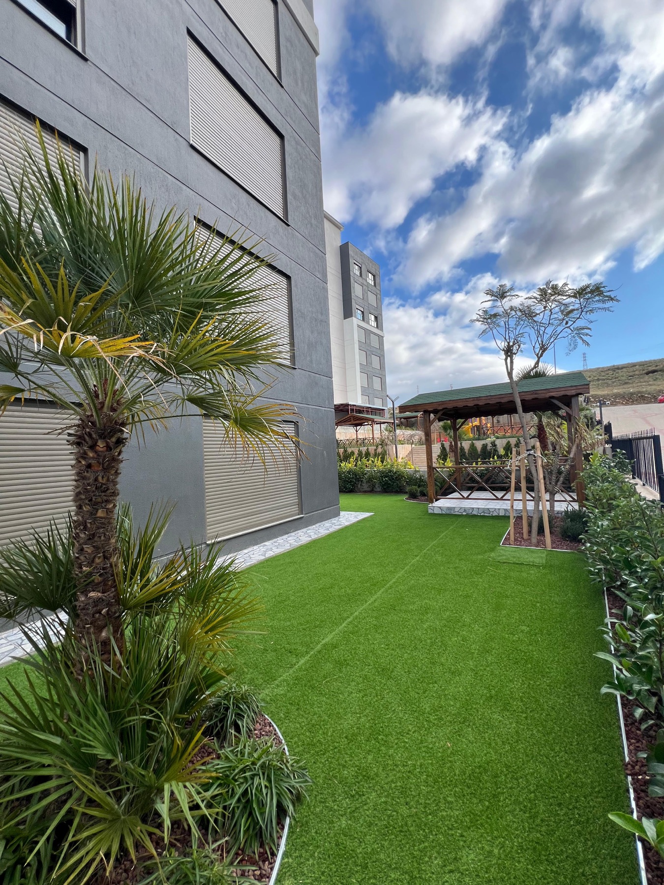 Tamamlanan Erkaya Twins’de bahçe katlarının önündeki yeşil alan ve pergola